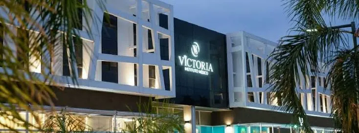 Fachada de Instituto Médico Victoria de noche, con su cartel iluminado